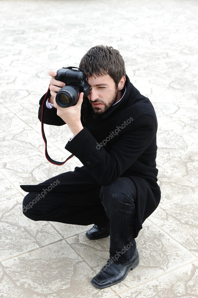 Young professional man with camera shooting outdoor