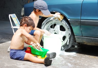 A little cute kid is cleaning car, outdoor clipart