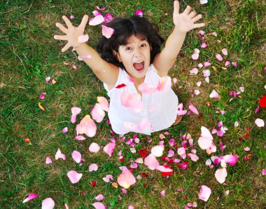 Happy beautiful girl on ground with rose's petals clipart