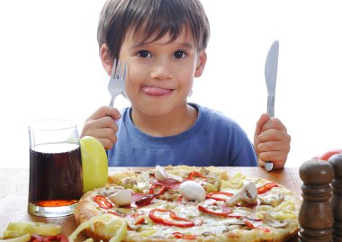 Cute little boy eating pizza on table, isolated clipart