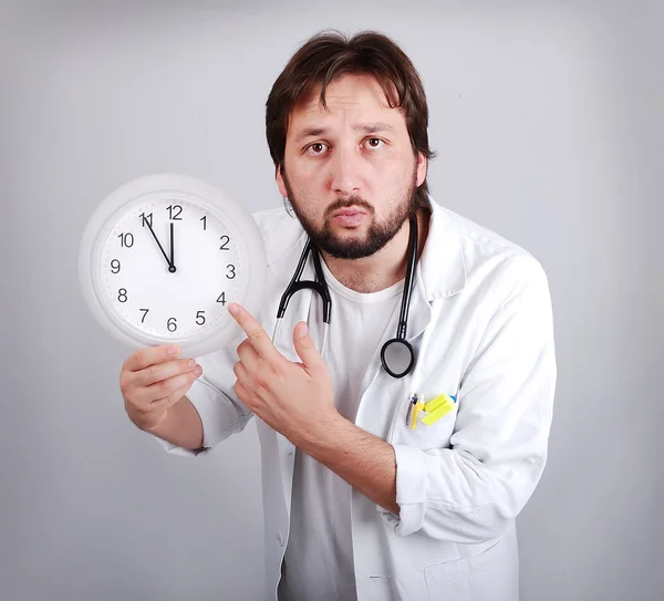 Erkek doktor bir çalar saat işliyor dışarı tutarak daha yakın 12 için — Stok fotoğraf