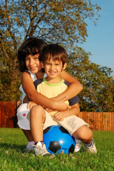 Zwei niedlich lächelnde Kinder diskutieren auf der Wiese.. — Stockfoto