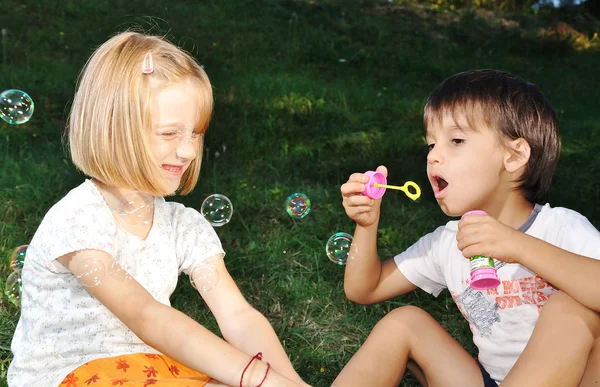 Ευτυχής χαριτωμένα παιδιά που έπαιζαν με φυσαλίδες — Φωτογραφία Αρχείου