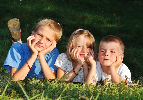 Šťastné krásné děti položila na zem venkovní — Stock fotografie