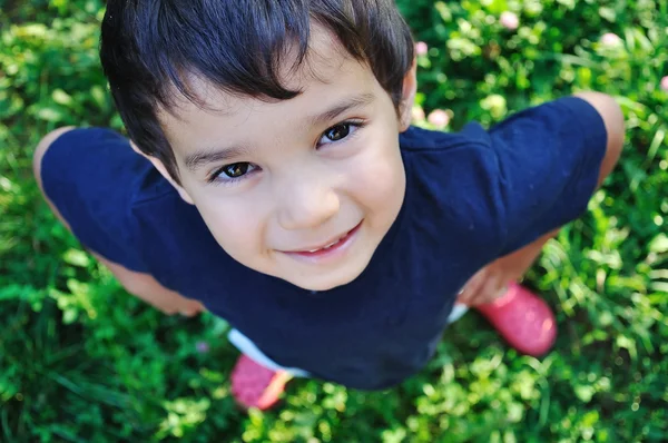 Criança bonita feliz no chão ao ar livre — Fotografia de Stock