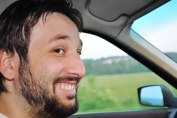 驾驶一辆车和微笑着大胡子的年轻男性 — 图库照片
