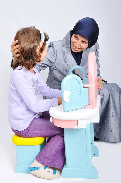 Fiatal muzulmán nő játszik, és a tanulás a kislányom — Stock Fotó