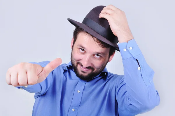 Joven con sombrero y apuntando con el pulgar hacia arriba —  Fotos de Stock