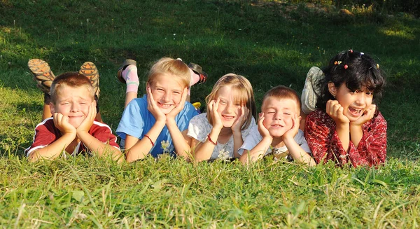 Niños juntos, felicidad en el prado verde en verano — Foto de Stock