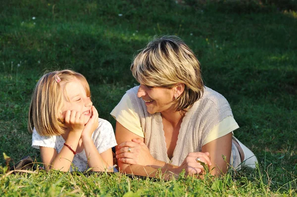 Criança com mãe, felicidade em prado verde em tempo de verão — Fotografia de Stock