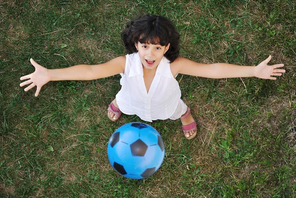 Kleines nettes Mädchen spielt mit einem Ball in der Luft — Stockfoto