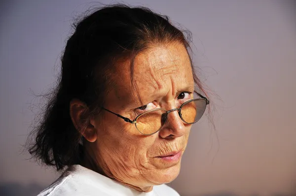 Argt ansikte av äldre kvinna med fin bakgrund — Stockfoto