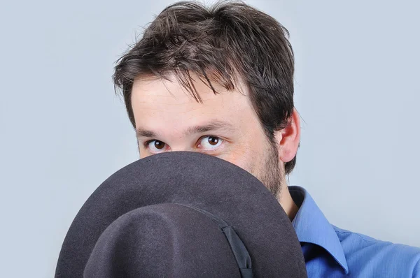 Молодой привлекательный мужчина в голубой рубашке и шляпе — стоковое фото
