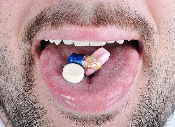 Comprimidos na língua do homem — Fotografia de Stock