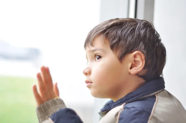 Um miúdo à espera na janela. — Fotografia de Stock