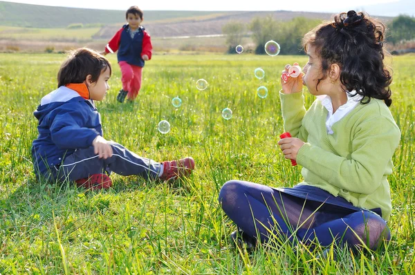 Brincando com bolhas no prado — Fotografia de Stock