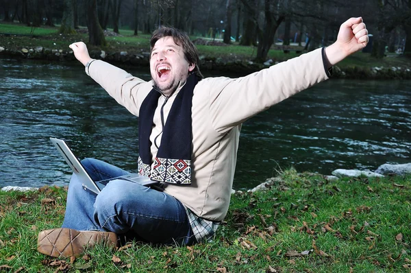 Jonge man met laptop buiten — Stockfoto