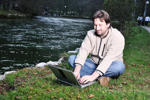 Jovem com laptop ao ar livre — Fotografia de Stock