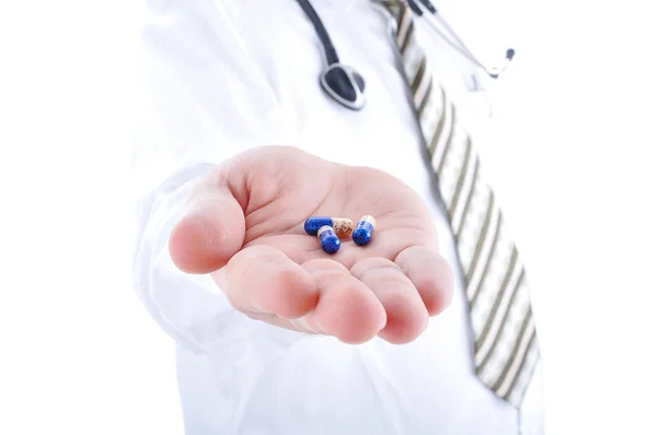 Médico holding pílulas na palma da mão — Fotografia de Stock