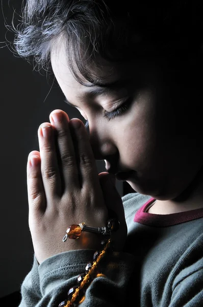 Chica rezando en la oscuridad —  Fotos de Stock