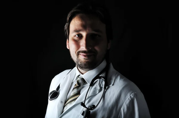 Mladý atraktivní muž lékař v charakteristické oblečení — Stock fotografie