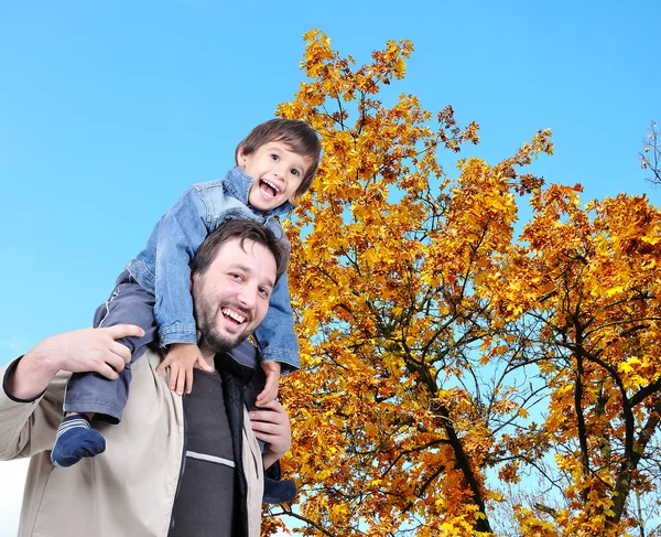 Šťastný otec a jeho syn na zádech, podzim — Stock fotografie