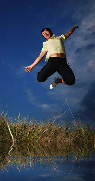 Jovem homem ativo pulando, escuridão — Fotografia de Stock