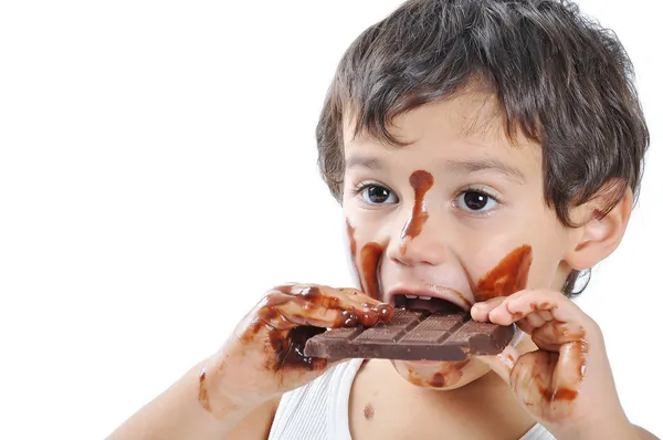 Lilla söta unge med choklad på ansikte och händer — Stockfoto