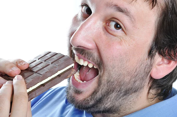 Happy young man eating chocolate — Stock Photo, Image