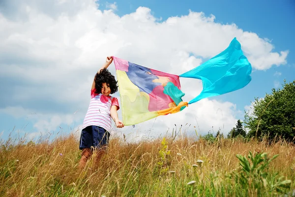 Malá roztomilá dívka hospodářství šátek na větru, venkovní — Stock fotografie