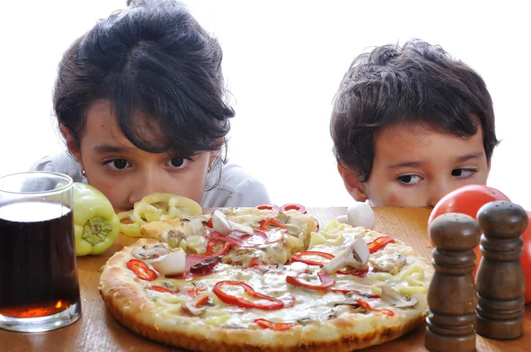 Pizza tablo sürpriz yüz ile iki çocuk — Stok fotoğraf