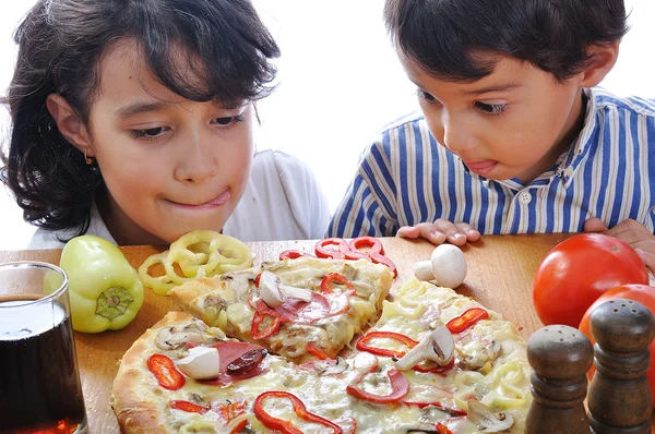 Δύο παιδιά με έκπληξη ενόψει στο τραπέζι πίτσα — Φωτογραφία Αρχείου