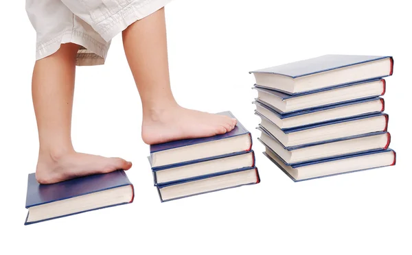 Kleine Beine, die auf Büchertreppen treten, isoliert — Stockfoto