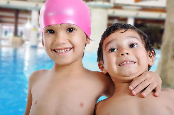 Pequenas crianças bonitos na piscina — Fotografia de Stock