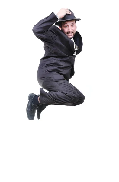 Young attractive businessman jumping with hat on head — Stockfoto