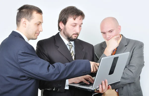 Tres jóvenes empresarios en el ordenador portátil — Foto de Stock