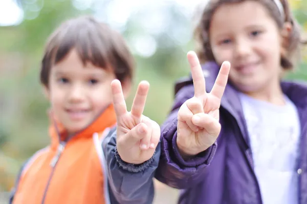 Due bambini, maschio e femmina con le dita della vittoria — Foto Stock