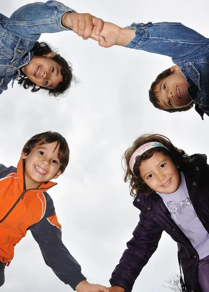 Czterech młodych dzieci trzymając się za ręce — Zdjęcie stockowe