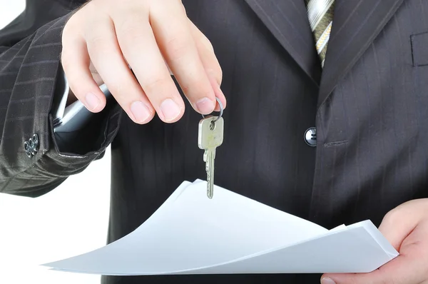 Uma mão de homem de negócios e a chave, acordo de papel — Fotografia de Stock