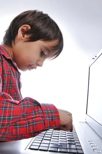Niño lindo sentado con el ordenador portátil —  Fotos de Stock