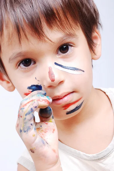 Pequeno garoto bonito com cores em seu rosto — Fotografia de Stock