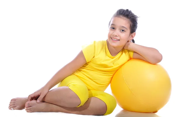 Liten vacker flicka i gul med gul boll — Stockfoto