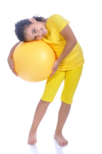 Маленька красива дівчинка в жовтому з жовтим м'ячем — стокове фото