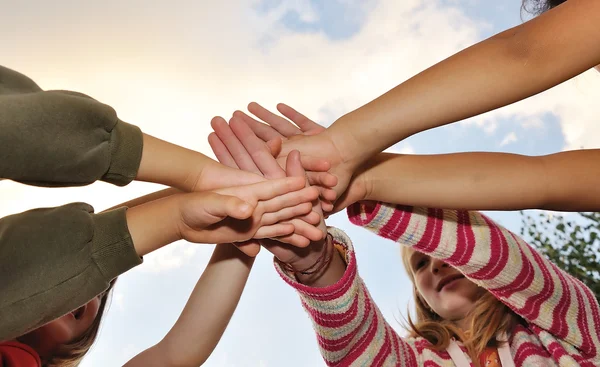 Small group of happy children outdoor, their hands crossed — Stock Photo, Image