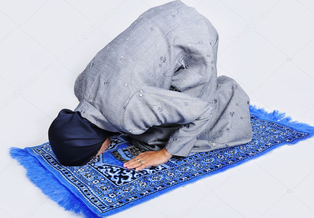 Young muslim woman praying on traditional way