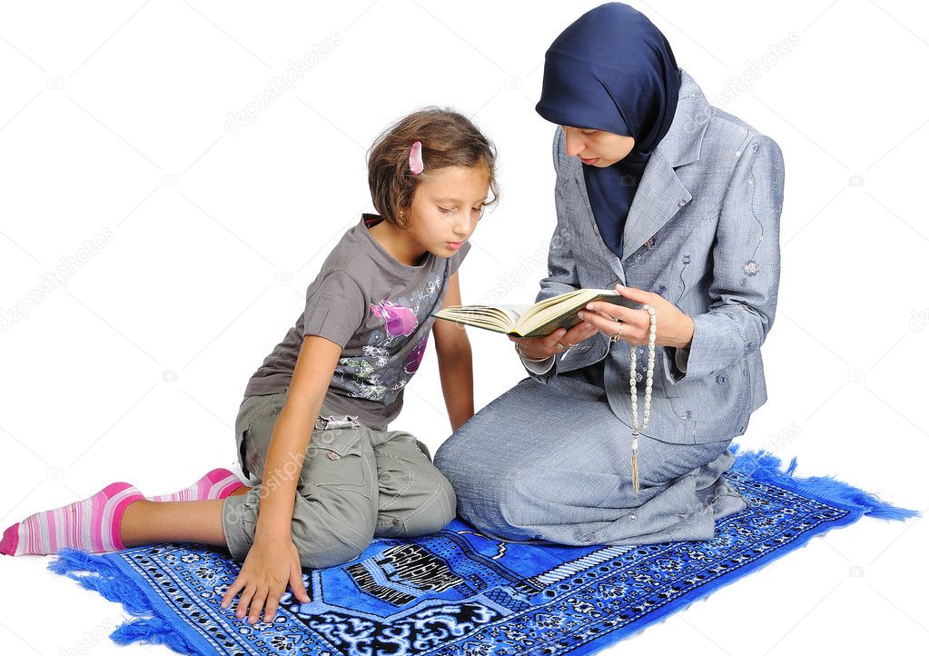 Young nice muslim female teaching her daughter