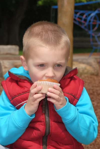 Blonde jongetje eten muffin — Stockfoto