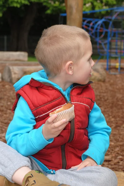 Blonde jongetje eten muffin — Stockfoto