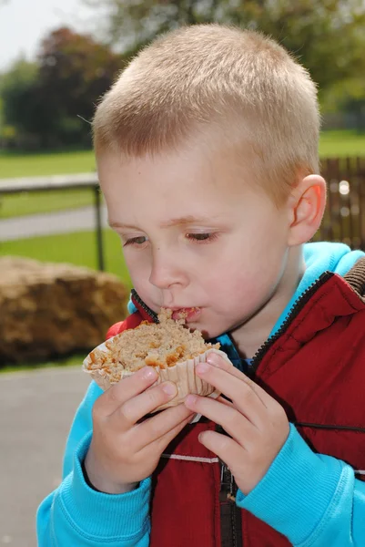 Loira menino comendo muffin — Fotografia de Stock