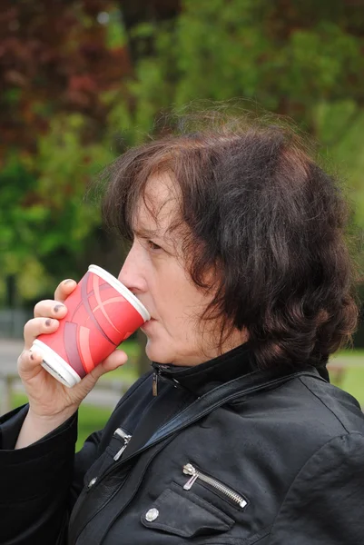 Ώριμη γυναίκα που πίνει καφέ στο πάρκο — Φωτογραφία Αρχείου